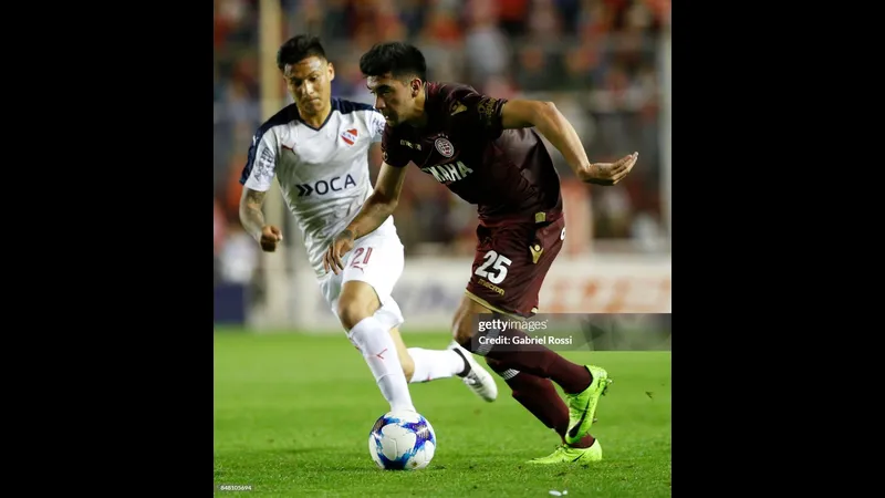 Cầu thủ Independiente điều chỉnh bóng giữa áp lực từ cầu thủ Lanus