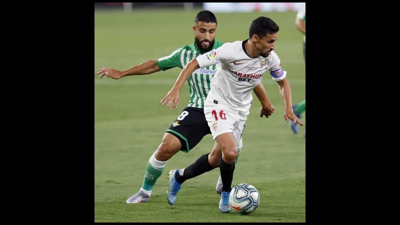 Cầu thủ của Sevilla nỗ lực đi bóng qua cầu thủ của Real Betis trong trận đấu.